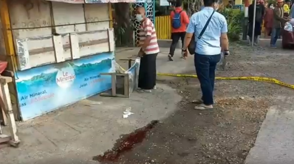 Polisi memasang police line di lokasi penemuan mayat bersimbah darah depan warung kopi. (metrotv)