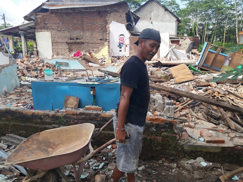 lustrasi--Korban bencana di Desa Majangtengah, Kecamatan Dampit, Malang, Agung Dwi Prayogo, membersihkan reruntuhan bangunan rumahnya. (Foto: MI/Bagus Suryo)
