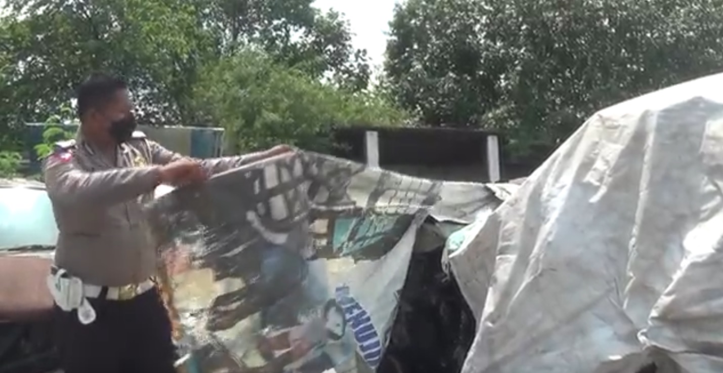 Petugas Laka Lantas Polres Jombang menutup mobil Vanessa Angel dengan banner lantaran dijadikan objek swafoto warga (Foto / Metro TV)