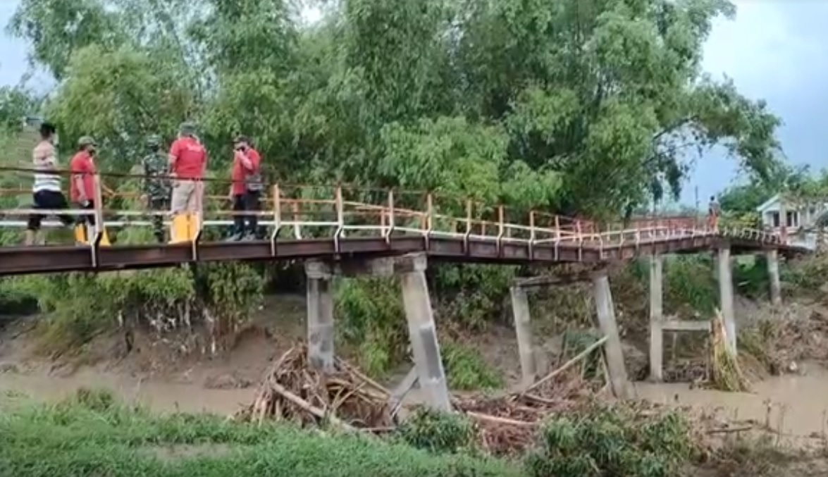 Sebuah jembatan penghubung desa nyaris roboh terkena luapan Sungai Lamong. (metrotv)