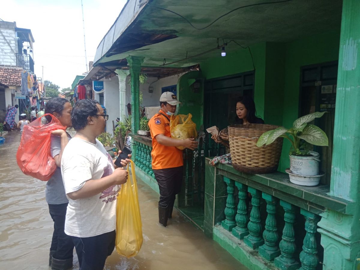 Petugas BPBD Pasuruan memberikan bantuan kepada warga yang terdampak banjir (Foto / istimewa)