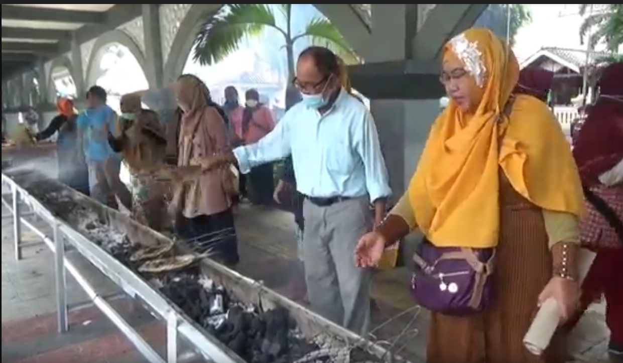 Keseruan warga Gresik membakar ikan bandeng gratis. (metrotv)