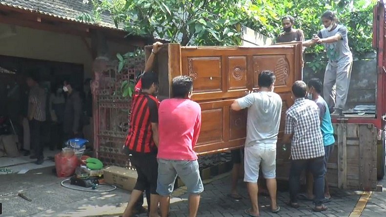 Sejumlah petugas mengangkut lemari saat proses pengosongan rumah di Surabaya (Foto / Istimewa)