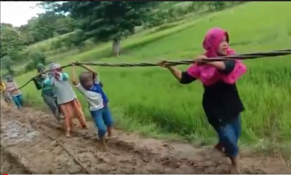 Demi Listrik, Ibu-ibu Angkat Kabel Melewati Jalan Berlumpur