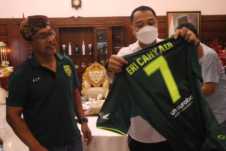 Pelatih Persebaya Aji Santoso saat memberikan jersey dengan nomor punggung 7 dan bertuliskan Eri Cahyadi saat berkunjung di rumah dinas wali Kota Surabaya, Minggu (2/1/2022). (FOTO ANTARA/HO-Humas Pemkot Surabaya)
