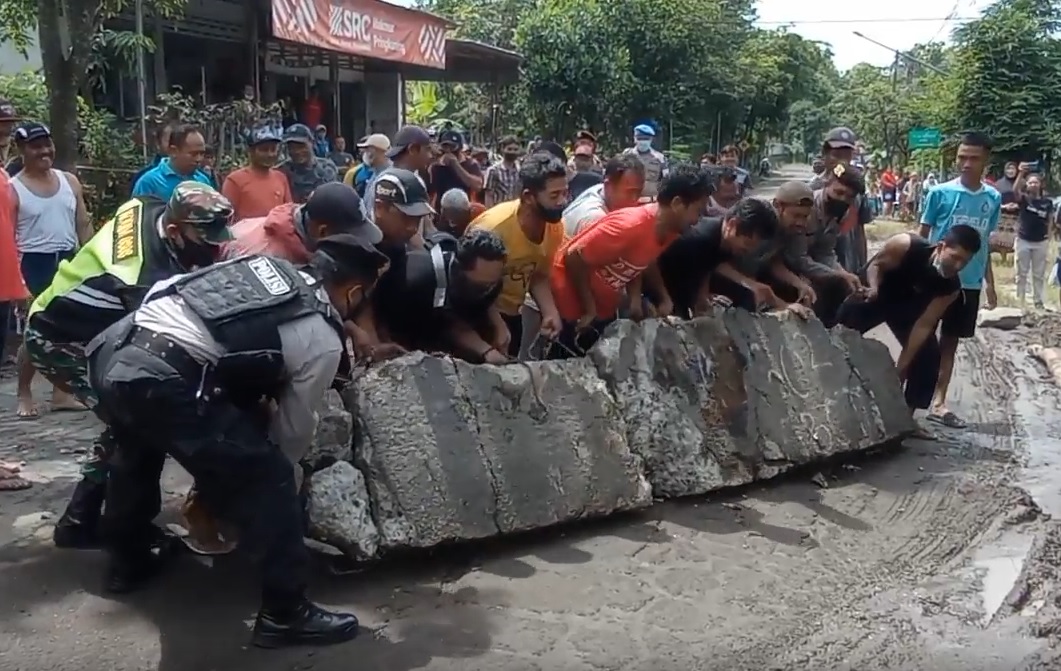 Aksi warga Blitar menutup paksa jalan menuju pabrik gula RMI.  (metrotv)