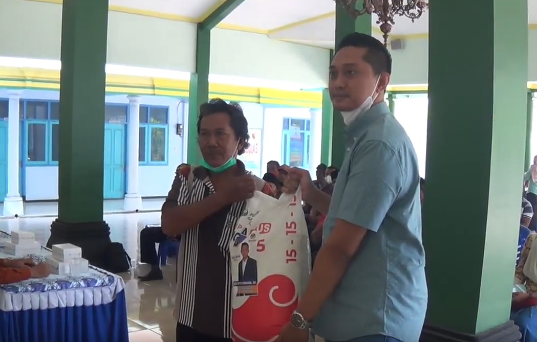 Janur Cipta, anggota Fraksi Partai Nasdem DPRD Kabupaten Magetan menyerahkan bantuan pupuk kepada petani. (metrotv)