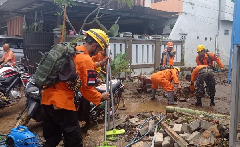 Petugas membersihkan sisa banjir bandang Jember yang menyapu rumah warga (Foto / Metro TV)