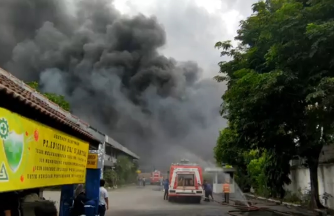 Kepulan asap tebal terlihat membubung dari bagian belakang bangunan pabrik sepatu dan sandal di Sidoarjo. (metrotv)