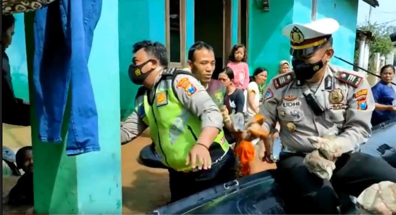 Jajaran Polres Pasuruan Kota membagikan nasi bungkus dengan menggunakan perahu karet kepada warga korban banjir. (metrotv)