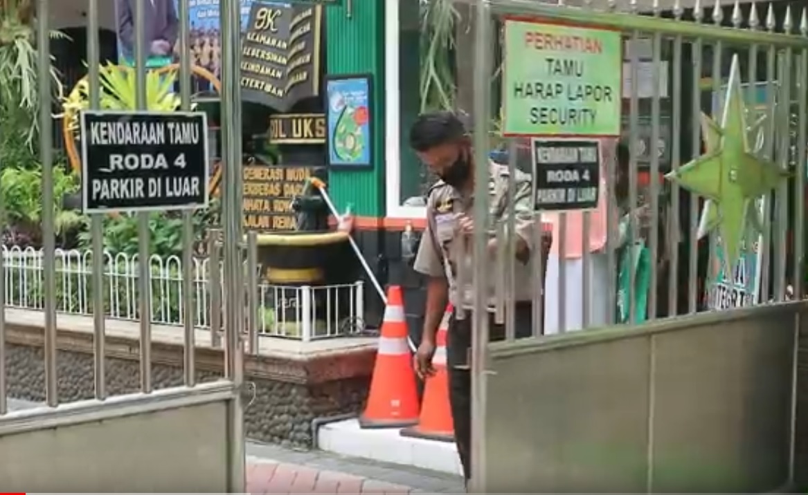 Petugas keamanan menuntup pintu pagar MAN 2 Kota Malang. (metrotv)