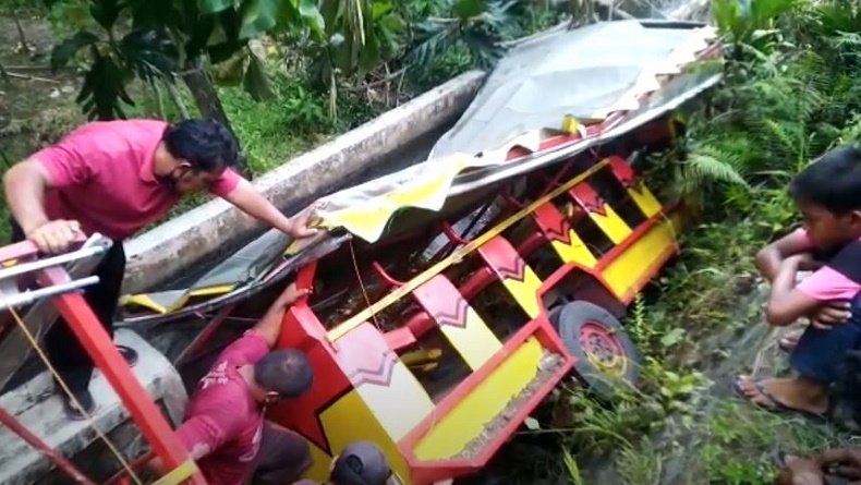 Warga mencoba mengevakuasi korban kereta kelinci yang terjun dari Jembatan (Foto / Metro TV)