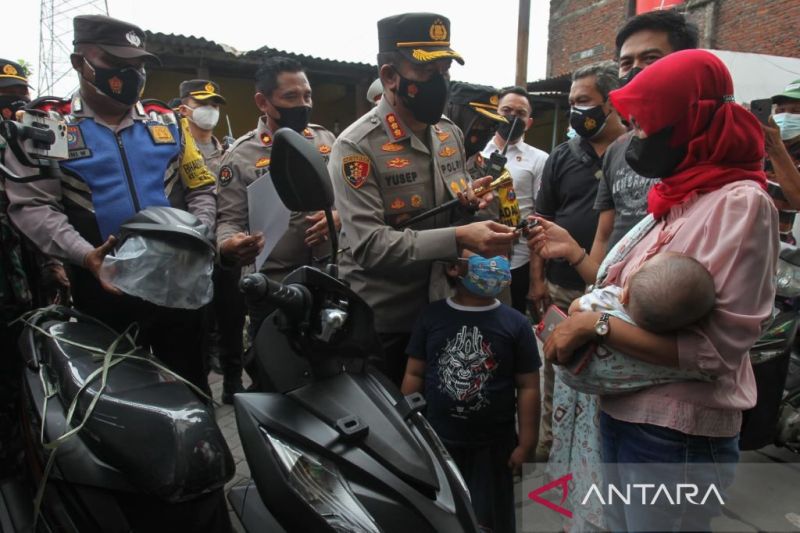 Kapolrestabes Surabaya Kombes Pol Akhmad Yusep Gunawan menyerahkan sepeda motor kepada pengojek daring yang menjadi korban pencurian sepeda motor di Surabaya, Senin (14/2/2022). ANTARA/Didik Suhartono.