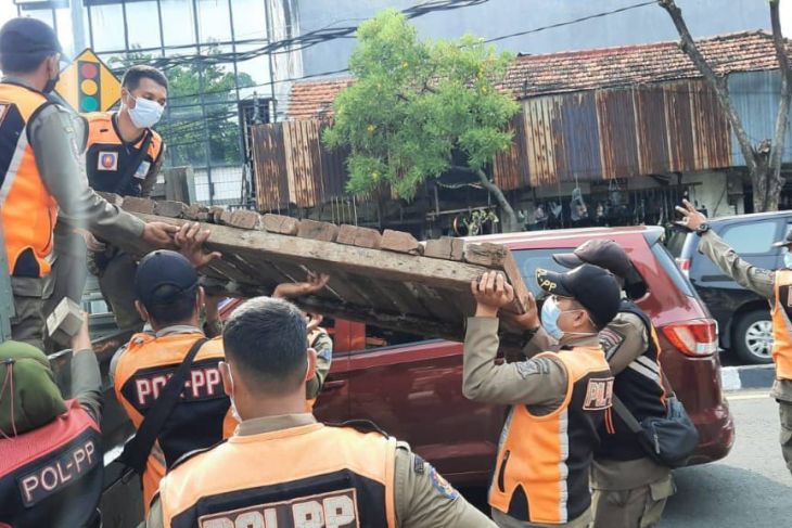 Petugas Satpol PP menertibkan pedagang kaki lima di pinggir Jalan kawasan Gembong Kota Surabaya, Selasa, 1 Februari 2022. Foto: Antara/HO-Diskominfo Surabaya