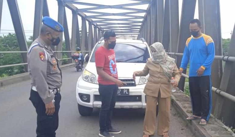 Korban dan polisi melakukan olah TKP perampokan guru SD di di Jembatan Tanjangrono (Foto / Istimewa)