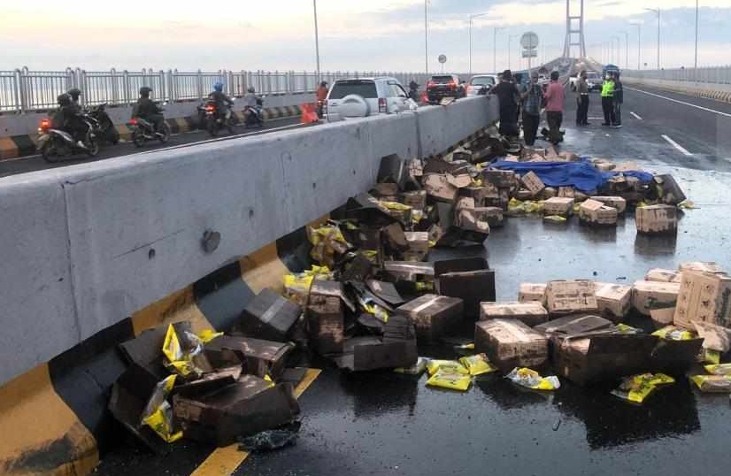 Puluhan kardus berisi minyak goreng tumpah setelah truk pengangkut terbalik (Foto / Metro TV)