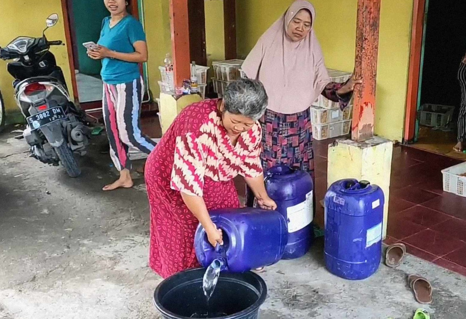 Siti Fatimah menunjukkan jirigen berisikan air yang dikira minyak goreng (Foto / Metro TV)