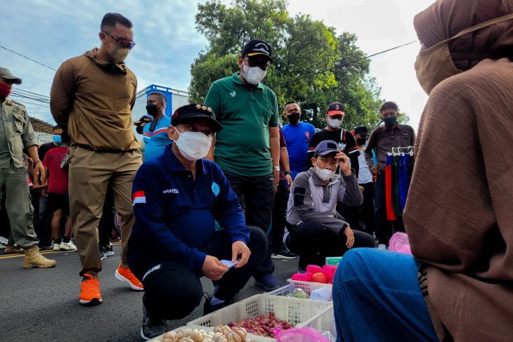 Bupati Situbondo Karna Suswandi (tengah) didampingi Kapolres AKBP Andi Sinjaya (kanan) berbincang dengan pedagang di kawasan Alun-Alun Situbondo. Minggu, 20 Maret 2022. Foto: Antara/Novi H