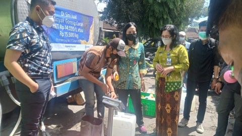 Para pedagang pasar mengisi jeriken dengan minyak goreng curah yang didistribusikan Dinas Koperasi Perdagangan dan Perindustrian Kota Malang di Pasar Bunul Kota Malang, Kamis 24 Maret 2022. Foto: Medcom.id