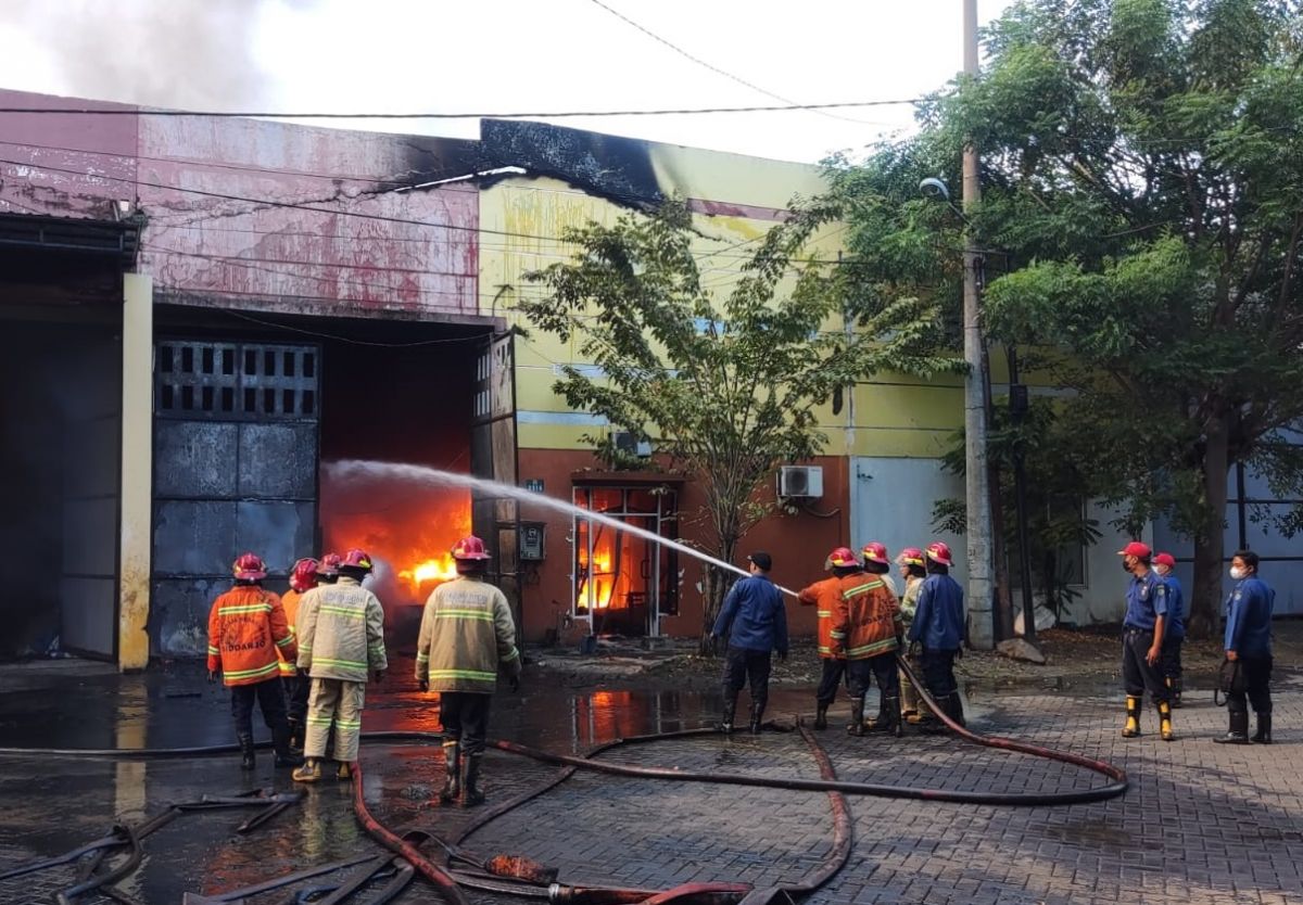 Petugas PMK saat mencoba memadamkan api di gudang limbah B3 milik PT SBS di Sidoarjo (Foto / Metro TV) 