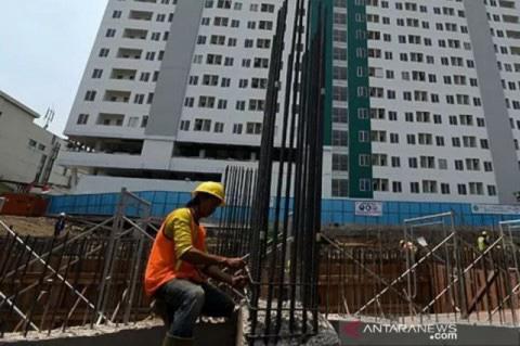 Pekerja menyelesaikan kontruksi pembangunan sebuah apartemen di Surabaya, Jawa Timur. Foto: Antara/Zabur Karuru/am