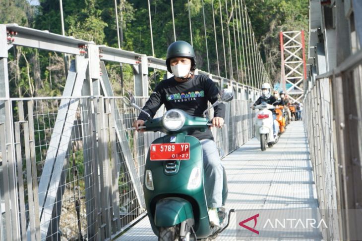 Bupati Lumajang Thoriqul Haq melintasi jembatan Gladak Perak dengan menggunakan sepeda motor usai peresmian dibukanya jembatan gantung Gladak Perak, Sabtu, 23 April 2022. Foto:/HO-Diskominfo Lumajang)