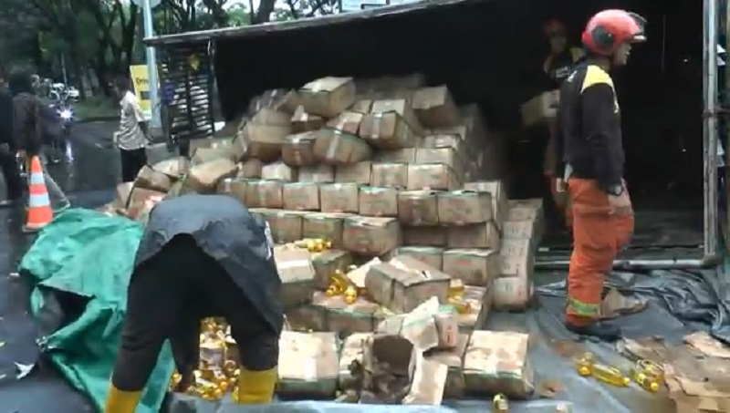 Truk muatan minyak goreng terguling hingga mengakibatkan ceceran minyak di jalan raya (Foto / Metro TV)