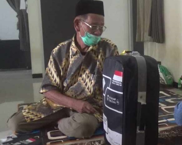 Dengan sedih Atman memandangi tas haji namun dia gagal berangkat (Foto / Metro TV)