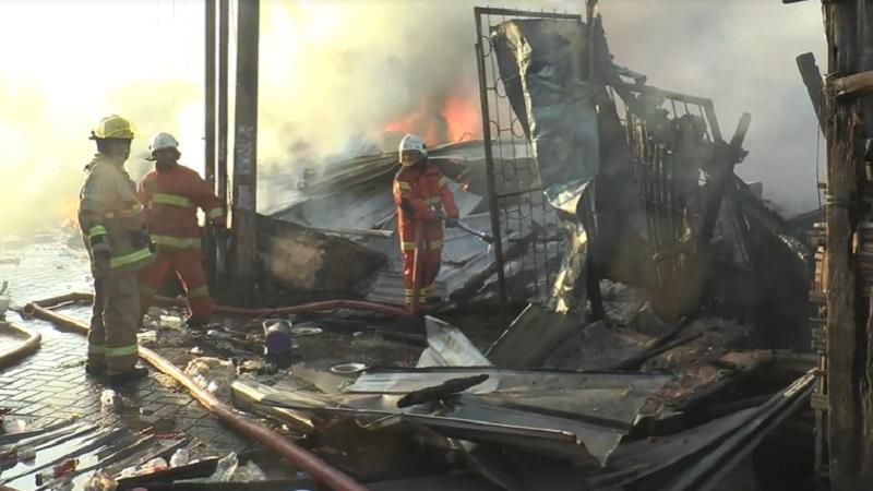 Petugas PMK mencoba memadamkan api yang membakar gudang barang bekas di Surabaya (Foto / Metro TV)