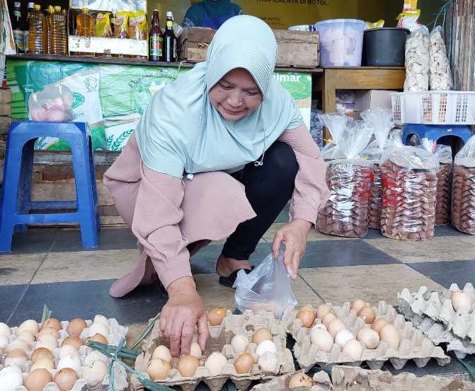 Salah satu pembeli telur retak di salah satu toko sembako di Magetan (Foto / Metro TV)