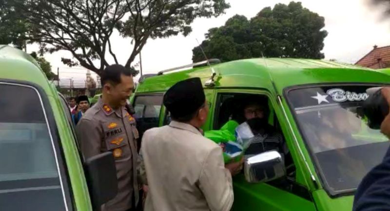 Kapolres Malang AKBP Ferli Hidayat membagikan paket sembako ke sopir angkot, ojek online hingga nelayan (Foto / Metro TV)