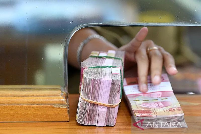 Ilustrasi: Karyawan memegang mata uang rupiah di gerai penukaran mata uang asing di Kwitang, Jakarta Pusat. ANTARA FOTO/Sigid Kurniawan/aww. (ANTARA FOTO/SIGID KURNIAWAN)