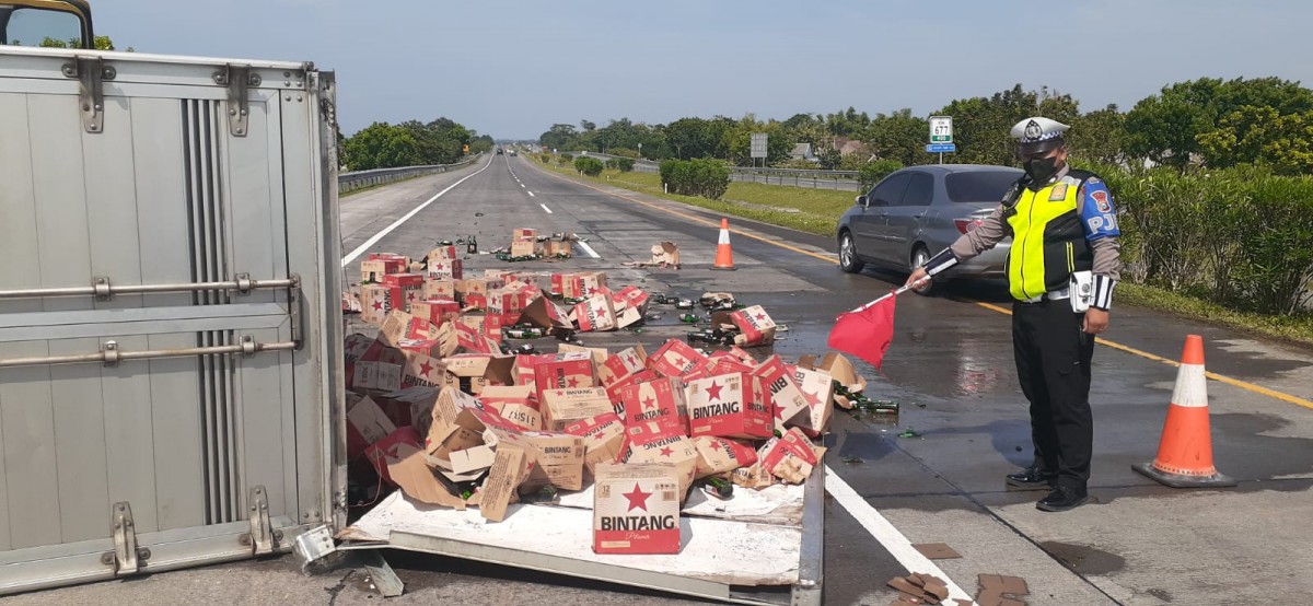 Ratusan karton bir berhamburan di jalan usai truk pengangkut alami pecah ban (Foto / PJR)