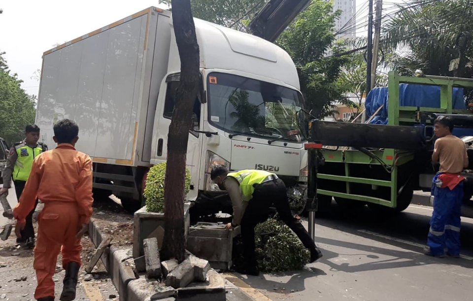 Kondisi truk ekspedisi yang menabrak pembatas jalan usai hindara pemotor (Foto / Istimewa)