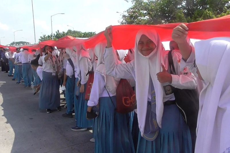 Ribuan guru dan siswa di Surabaya membentangkan bendera merah putih sepanjang 3.219 meter di Jembatan Suramadu dalam rangka memperingati Hari Pahlawan, Kamis (10/11/2022). (ANTARA/Hanif Nashrullah)
