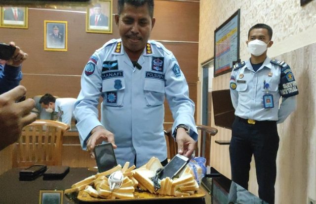 Petugas menununjukkan upaya penyelundupan hp dalam roti tawar (Foto / Istimewa)