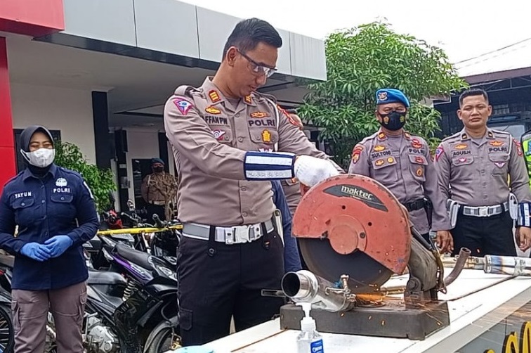 Kasatlantas Polres Ponorogo, AKP Affan Priyo Wicaksono saat memotong knalpot brong hasil razia polisi (Foto / Istimewa)