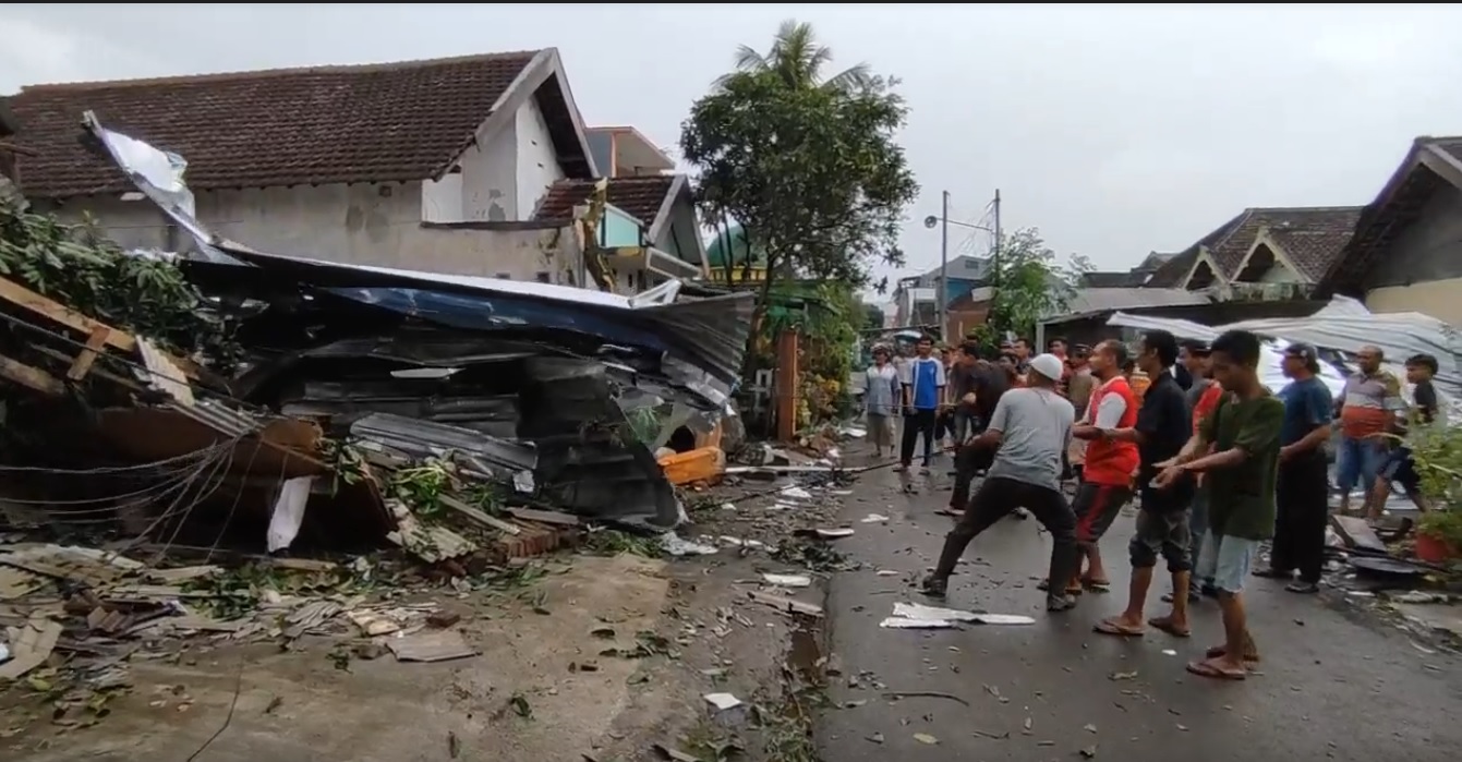 Warga gotong royong menyingkirkan atap yang menimpa rumah warga akibat diterjang puting beliung (Foto / Metro TV)