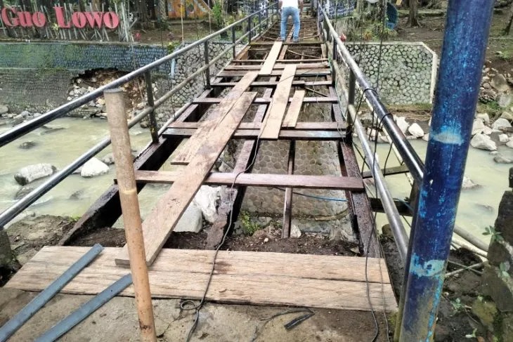  Pekerja memperbaiki jembatan gantung menuju pintu Goa Lowo di Kecamatan Watulimo, Trenggalek, Jumat (16/12/2022) (ANTARA/HO - Humas Pemkab Trenggalek)