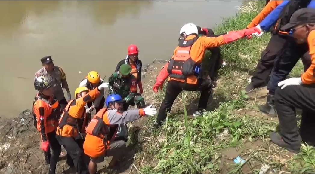 Petugas mengevakuasi jasad korban ke tepi Sungai Bengawan Solo/metrotv
