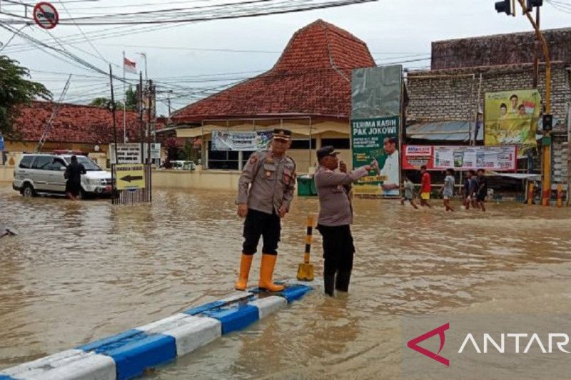 Petugas Polres Sampang mengatur arus lalu lintas di lokasi banjir di Kota Sampang, Jawa Timur, Minggu, 1 Januari 2023. Antara/HO-Polres Sampang