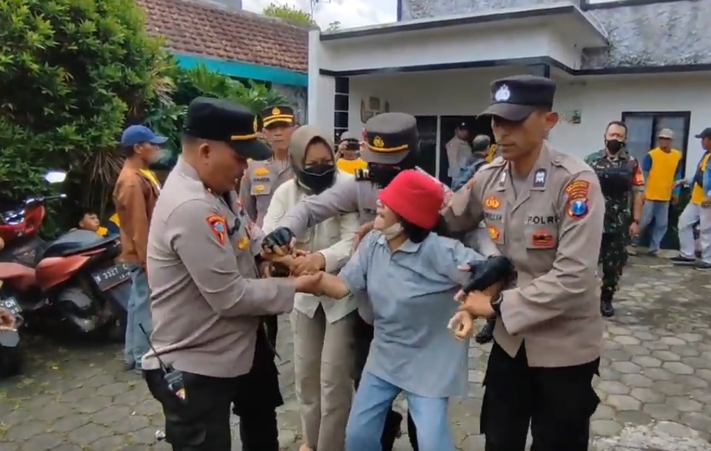 Petugas terpaksa mengamankan pemilik rumah lantaran mencoba melakukan pembakaran (Foto / Metro TV)