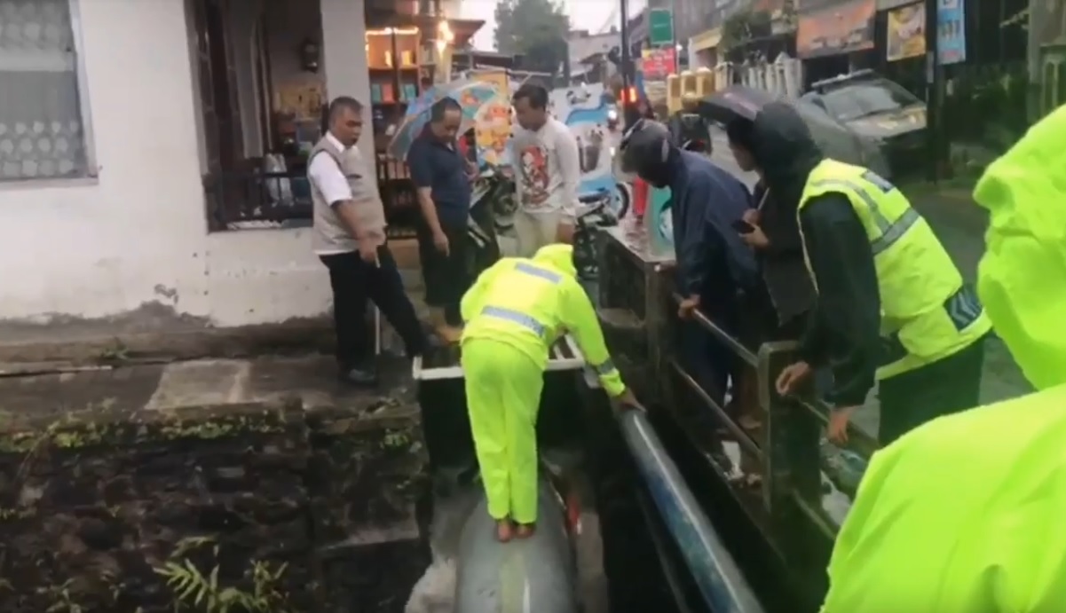 Petugas berupaya mencari bocah tenggelam di selokan (Foto / Metro TV)