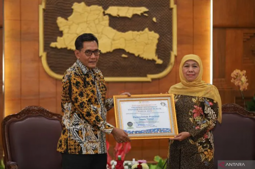 Anggota Ombudsman Johanes Widijantoro (kiri) penyerahan piagam penghargaan Kepatuhan Standar Pelayanan Publik Tahun 2022 kepada Gubernur Jawa Timur Khofifah Indar Parawansa (kanan) di Gedung Negara Grahadi, Surabaya, Rabu (1/2/2023). ANTARA FOTO/Rizal Han