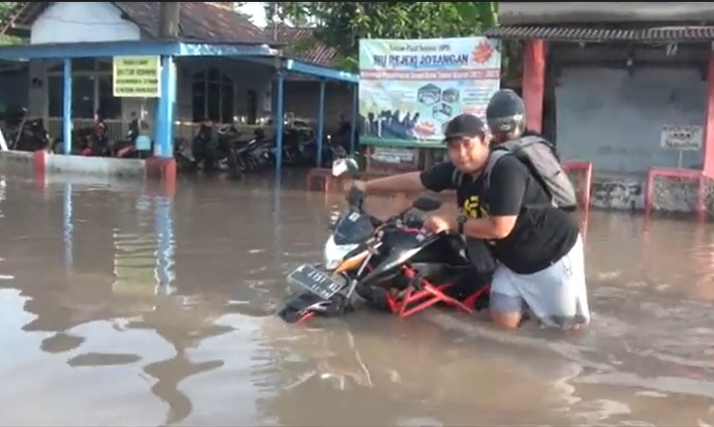 Salah satu warga mengevakuasi kendaraan dari rendaman banjir (Foto / istimewa)