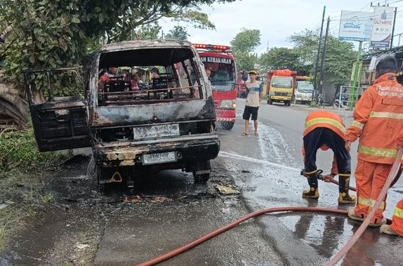 Petugas memadamkan api yang membakar mobil (Foto / istimewa)