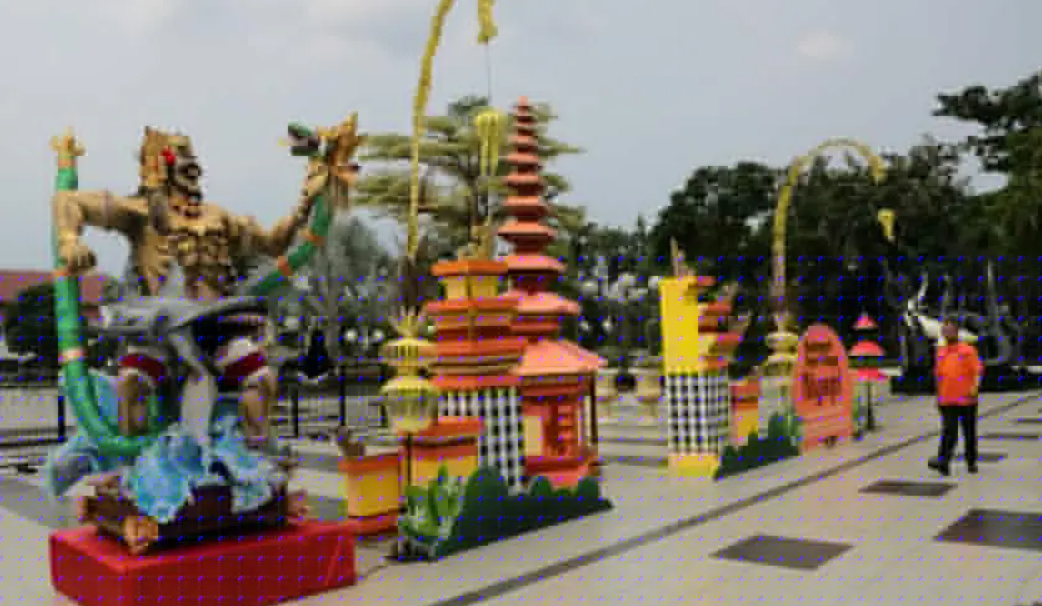 Tampak dari samping ornamen yang dipasang Dinas Lingkungan Hidup Kota Surabaya berbentuk Pura dan Ogoh-ogoh di depan halaman Balai Kota, lengkap dengan pernak-pernik, mulai janur, motif kain poleng, dan tedung atau pajeng (payung), Rabu (8/3/2023). Foto: 