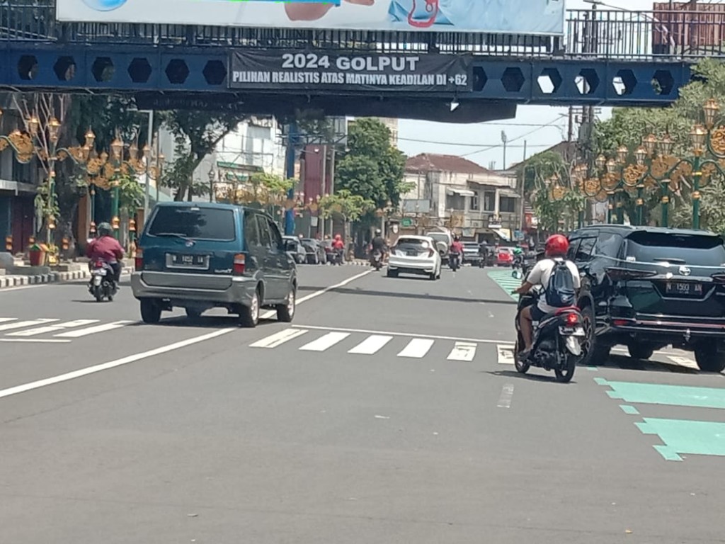 Spanduk 2024 Golput membentang di jembatan penyeberangan di Jalan Jenderal Basuki Rachmat, Kota Malang, Jawa Timur.