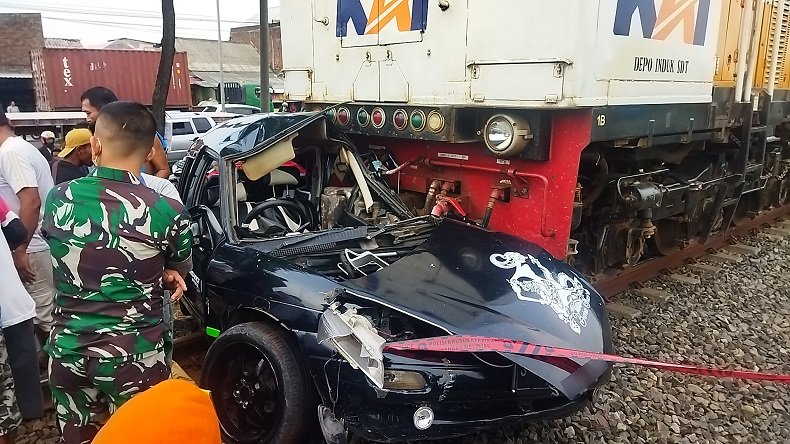 Kondisi mobil sedan yang ditumpangi bapak anak hancur setelah dihantam kereta api (Foto / Metro TV)