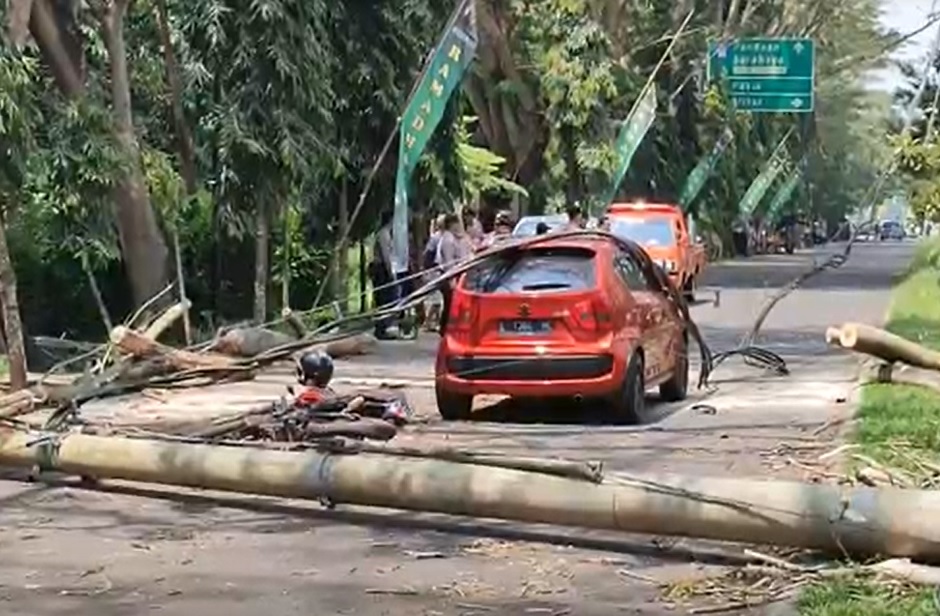 Tiang listrik dan pohon tumbang menimpa motor dan mobil di barat exit Tol Madyopuro, Kota Malang/metrotv